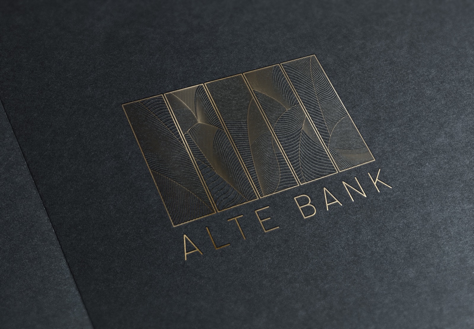 Logo der Alten Bank in Goldprägung auf dunklem Papier